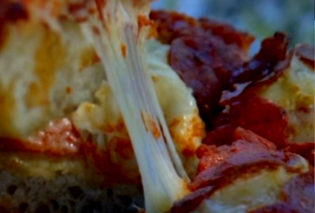 Detroit-style pepperoni pizza with melted cheese pull and crispy crust at Sierra Vista Winery in Placerville, California